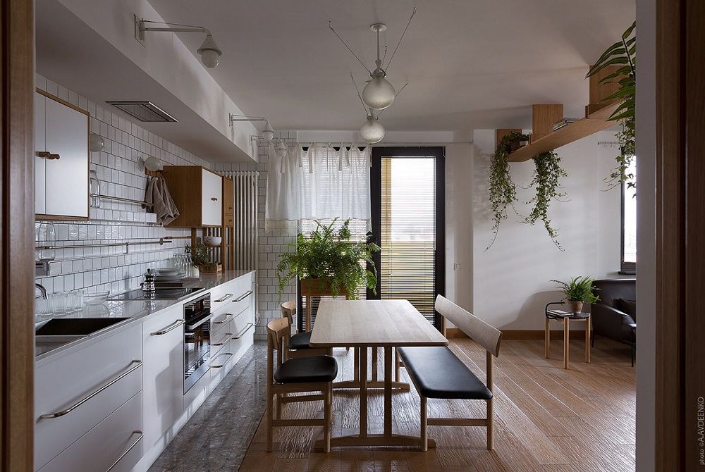 Bếp của chung cư phong cách tối giản được sắp xếp gọn gàng, kế bên là bàn ăn xinh xắn